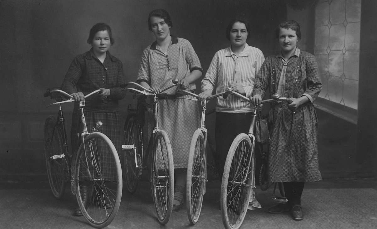 Vier junge Frauen mit ihren Fahrrädern, historische Aufnahme
