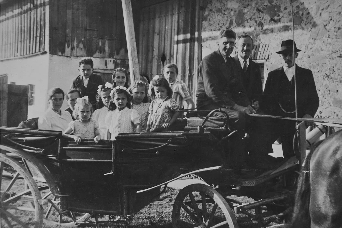 Familie in einer Pferdekutsche vor einem Haus, historische Aufnahme